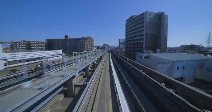 A point of view of a moving backward urban monorail at the downtown in Tokyo