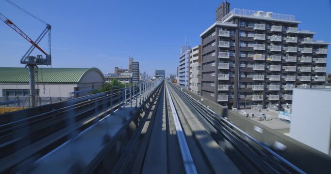A point of view of a moving backward urban monorail at the downtown in Tokyo