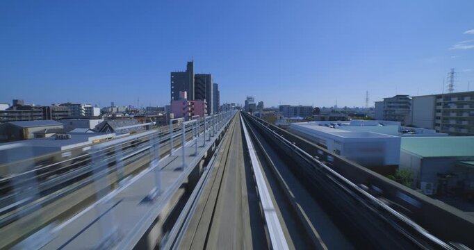 A point of view of a moving backward urban monorail at the downtown in Tokyo