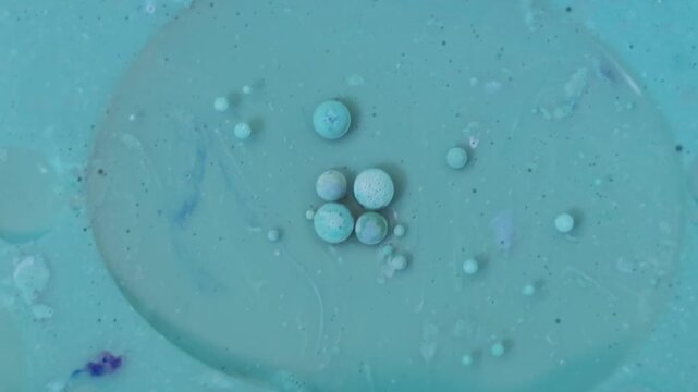 Una toma de cerca de varias burbujas de agua y aceite en movimiento en un fondo de color azul