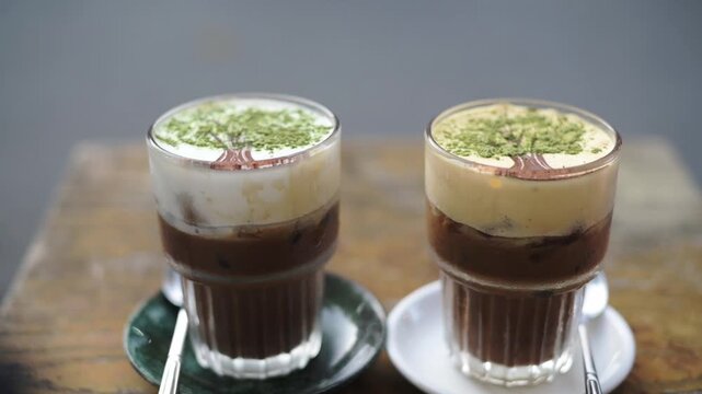 Clean Modern Coffee Presentation. Serene Cafe Scene Featuring Latte Art And Contrasting Beverages. Contemporary Cafe Still Life With Two Cappuccinos Showcasing Artistic Foam And Contrasting Drinks