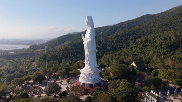 White Statue Overlooking Bay And Distant City Skyline, Coastal Viewpoint At Son Tra With Boats And Shoreline Visible, Blessing Scene For Fishermen And Morning Haze Over Da Nang, Vietnam