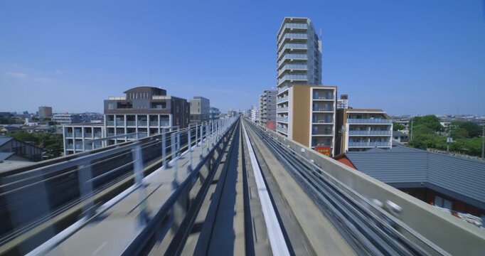 A point of view of a moving backward urban monorail at the downtown in Tokyo
