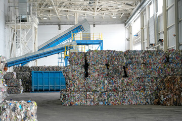 Overview pressed plastic bottles stacked into cubes at a waste sorting and recycling plant, in the...