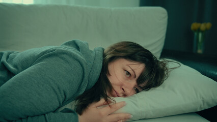 Tired Woman Lying on Couch Pillow in Casual Hoodie, sad depressed woman