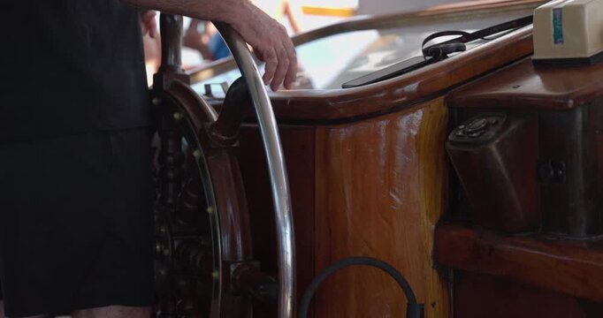Man steering large boat - close up on helm