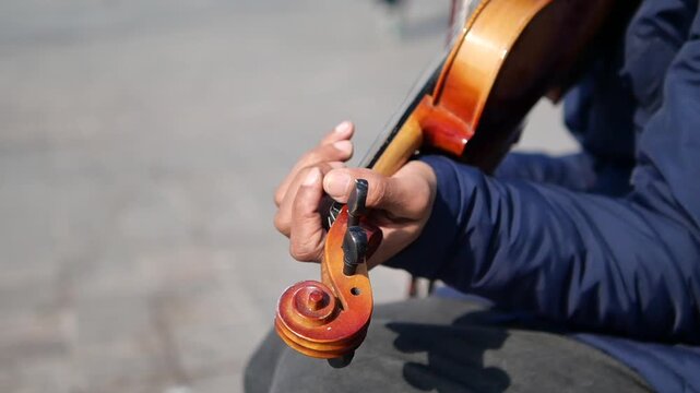 Music played on violin by street performer in city