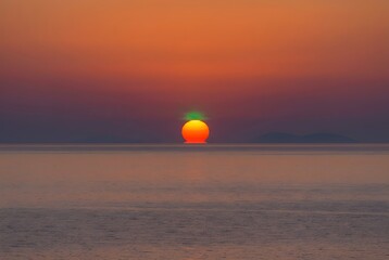 Green Flash phenomenon appearing at exact sunset over a perfectly flat Mediterranean sea horizon