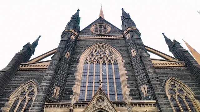Entrance of St Patrick&rsquo;s Cathedral in Melbourne, Victoria, Australia, featuring a Gothic Revival stone fa&ccedil;ade with pointed arches, ornate carvings. Religious landmark and tourist attraction in city