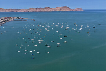 Aerial view of a bay with a group of yachts and boats anchored in waiting mode in front of islands © WILL PHOTOGRAPHY