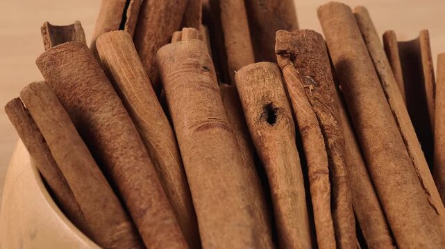 Dried cinnamon sticks in a wooden bowl
