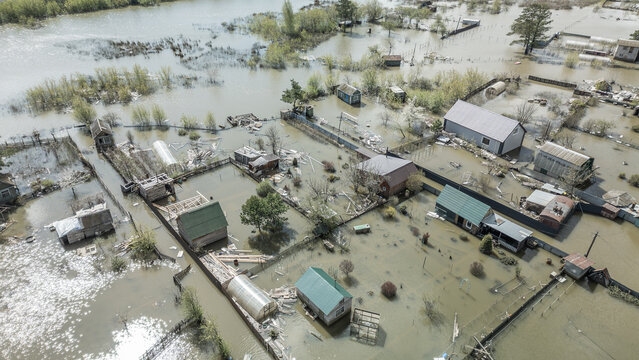 Spring flood disaster with fully submerged houses, flooded roads and overflowing waterways. The footage shows the dramatic impact of heavy rainfall and rising water levels on residential areas