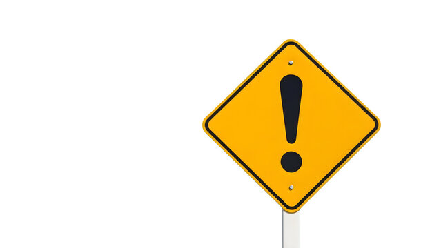 A yellow warning sign with an exclamation mark stands on a pole.