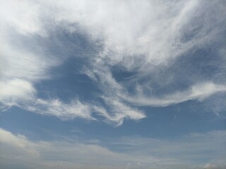 Fototapeta premium Abstract white wispy clouds on blue sky background with copy space for backgrounds and graphic design