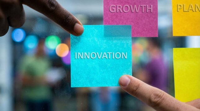 Two hands placing sticky notes with words like innovation and growth on a glass wall, representing business strategy and progress