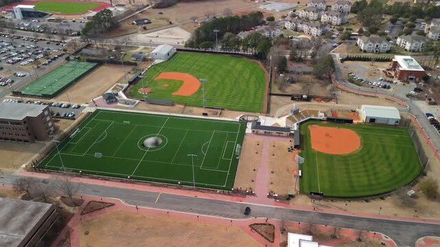 Drone view of campus sports complex with soccer field baseball diamonds and courts