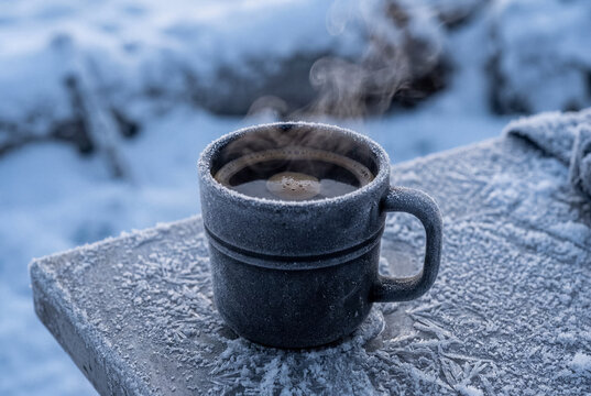 Cup of hot coffee with steam in sub-zero room