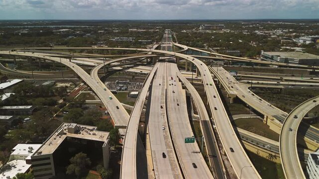 Drone rising over multilayer highway interchange with flowing traffic