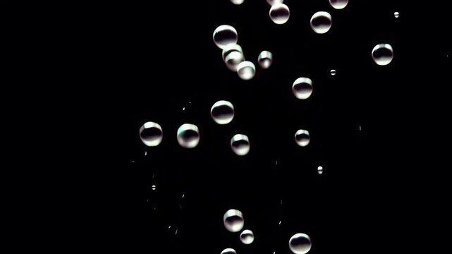 Many clear bubbles floating on dark background with shiny reflections