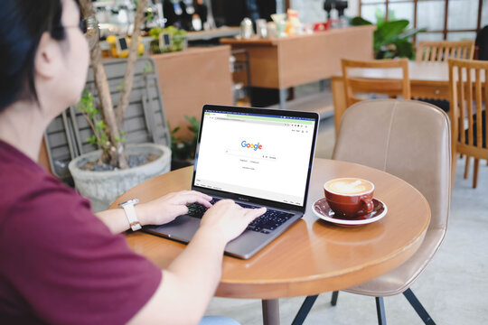 Bangkok, Thailand. March 14, 2026; A person using a MacBook Pro to browse the Google search engine home page while sitting in a modern cafe.
