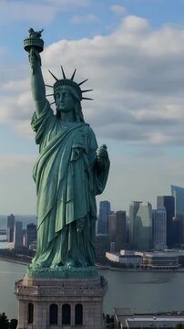 The Iconic Statue of Liberty: A Symbol of Freedom and Hope Overlooking the New York Harbor and Cityscape Under a Beautiful Sky