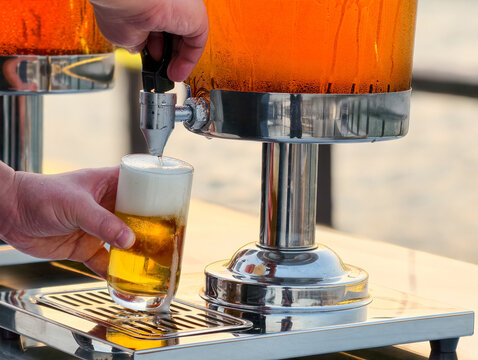 Pouring beer from a Beer tower e at outdoor restaurant