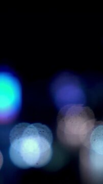 Cinematic feel smooth motion night city lights bokeh animation vertical video. Glowing blue circles blurred lightscape atmospheric dark scene vertical video,