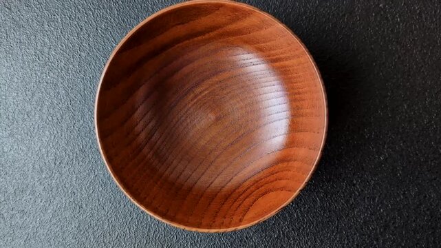 An empty round brown wooden bowl for Asian food. An empty wooden bowl as a food background for your design