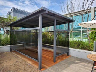 Fototapeta premium Modern rooftop terrace with glass smoking booth and wooden deck floor