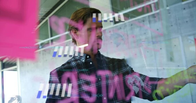 Mid-adult man shifting gaze and reaching glass, annotating pink marker notes for business planning