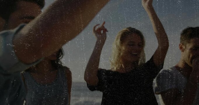 Man singing, crew dancing beach, song sparking waves, phone likes, raising cup celebrating travel