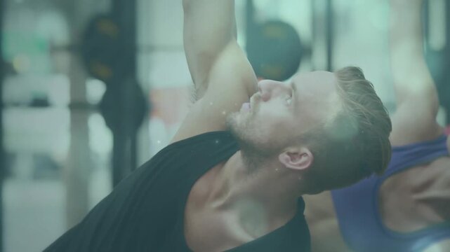 On cue participants doing side-stretch, camera panning to man in black, plates visible for fitness