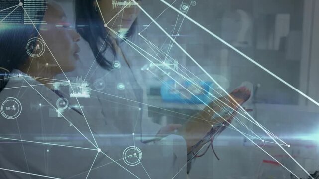 Vertical video: Diverse women in lab coats testing wired prototype while HUD sweeping over tablet