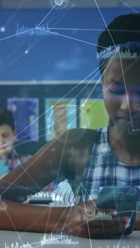 Vertical video: Pupil tapping phone for focus, HUD across lens as camera pulling back in classroom