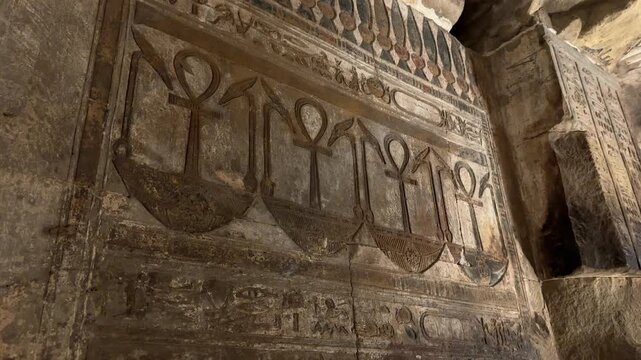 Detailed view of a row of ancient Egyptian Ankh symbols, representing life, carved as stone reliefs on the walls of the Temple of Hathor in Dendera