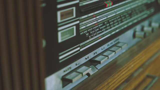 Close-up of finger operating control switch on retro 1970s radiogram radio player. Useful for vintage electronics, broadcasting equipment and retro technology visuals
