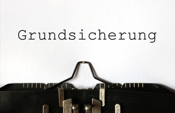 Grundsicherung auf Papier geschrieben mit Schreibmaschine &ndash; Konzept f&uuml;r Sozialhilfe, Existenzminimum und staatliche Unterst&uuml;tzung