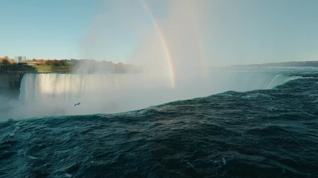 Niagara Falls with double rainbow above powerful waterfall and turbulent river water creating misty scenic natural landscape