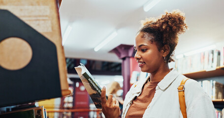 Obraz premium Student, girl and reading book at shelf at college for research, exam info and knowledge. University, african person and check resources in library for thesis citation, literary interest and learning