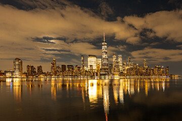 Fototapeta premium NYC night skyline. NYC downtown night view. New York City skyline at night. NYC glowing towers night.