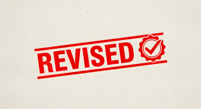 Red rubber stamp with the word revised and a checkmark seal on a textured paper surface