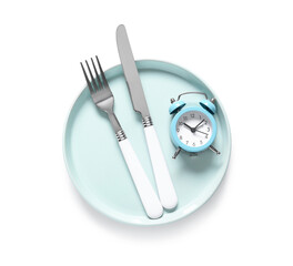 Naklejka premium Blue plate and cutlery with alarm clock on white background. Intermittent fasting concept