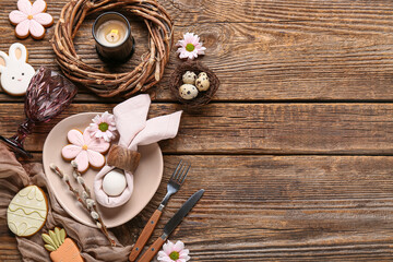 Beautiful table setting with different Easter cookies, eggs, burning candle and pussy willow branches on wooden background © Pixel-Shot