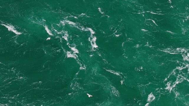 Aerial view of emerald Niagara River water surface with flowing currents and foam patterns