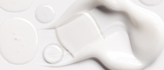 samples of cosmetic care products smear of cream and serum texture on a light background