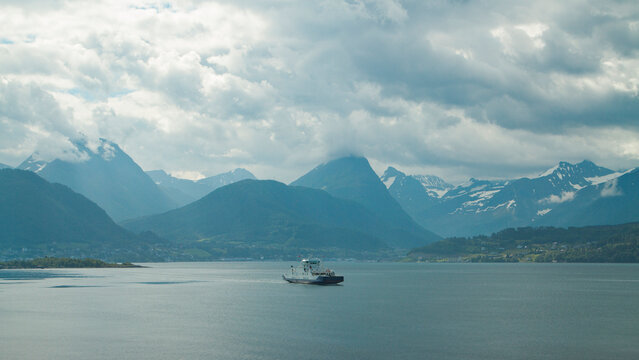  White passenger ferry sailing in majestic Norwegian fjord with mountains and copy space