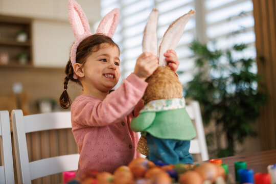 Little girl celebrating easter playing with bunny toy