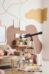 Fototapeta premium Interior of stylish children's room with sofa, toys and modern telescope