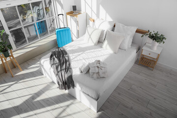 Plakat Interior of hotel room with bed, table and suitcase