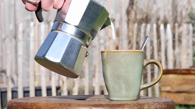 Shot of pouring milk into a mug with coffee.